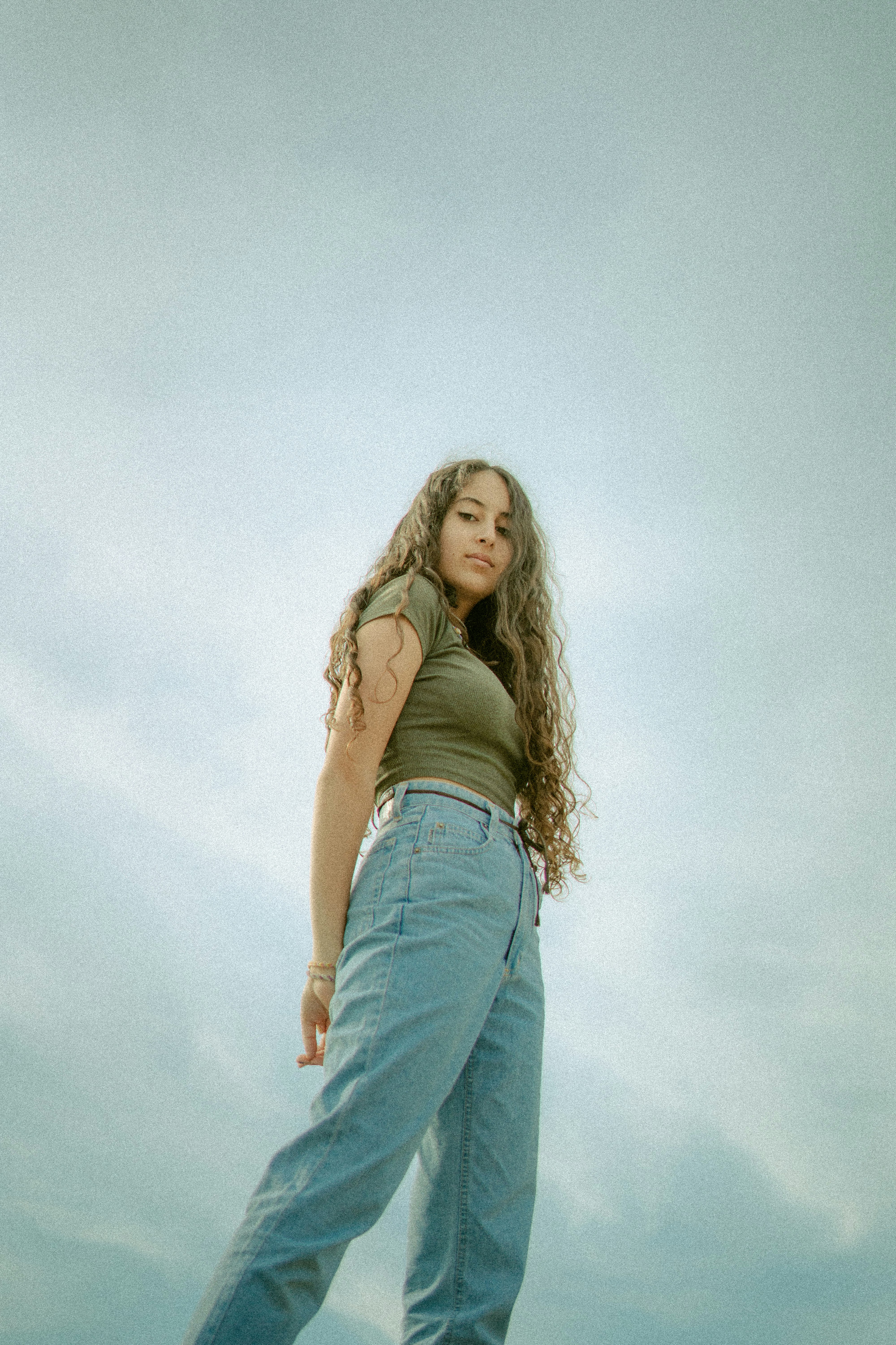 woman in brown tank top and blue denim jeans